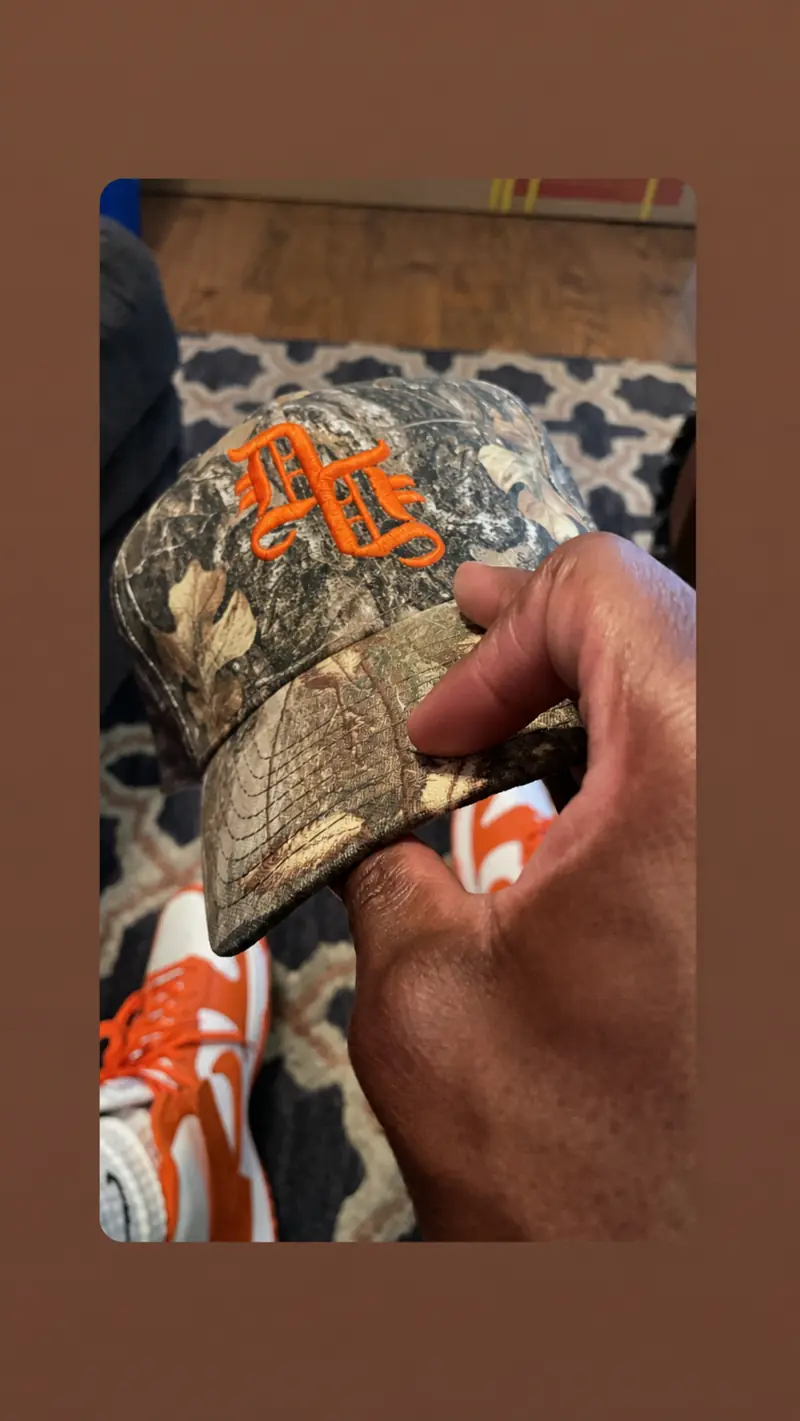Daily Denim & Co. camouflage cap with orange embroidered logo